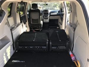 Fleet of mobility vans for rent parked near a beach.